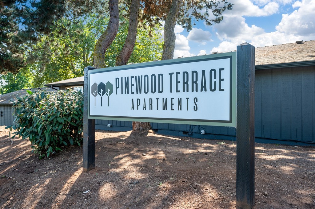 a sign that reads pinewood terrace apartments in front of a building