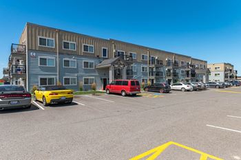 a parking lot with cars in front of a building