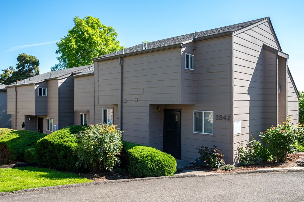 a grey building with a street in front of it