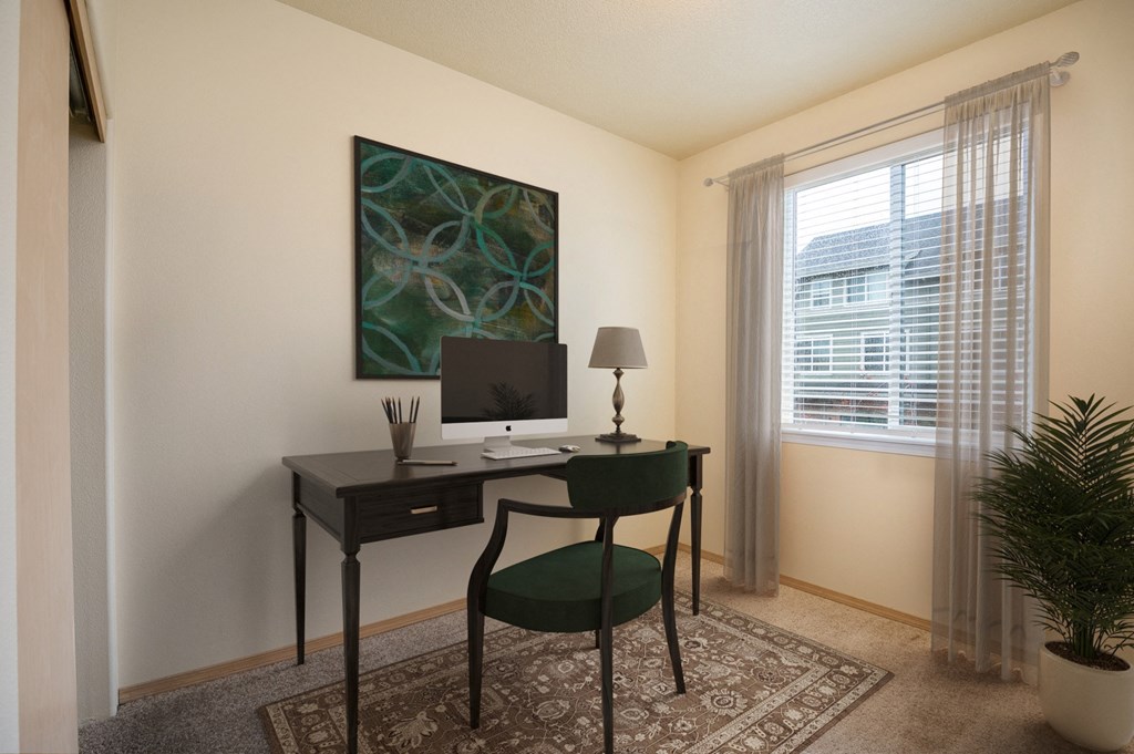 a room with a desk with a computer and a chair