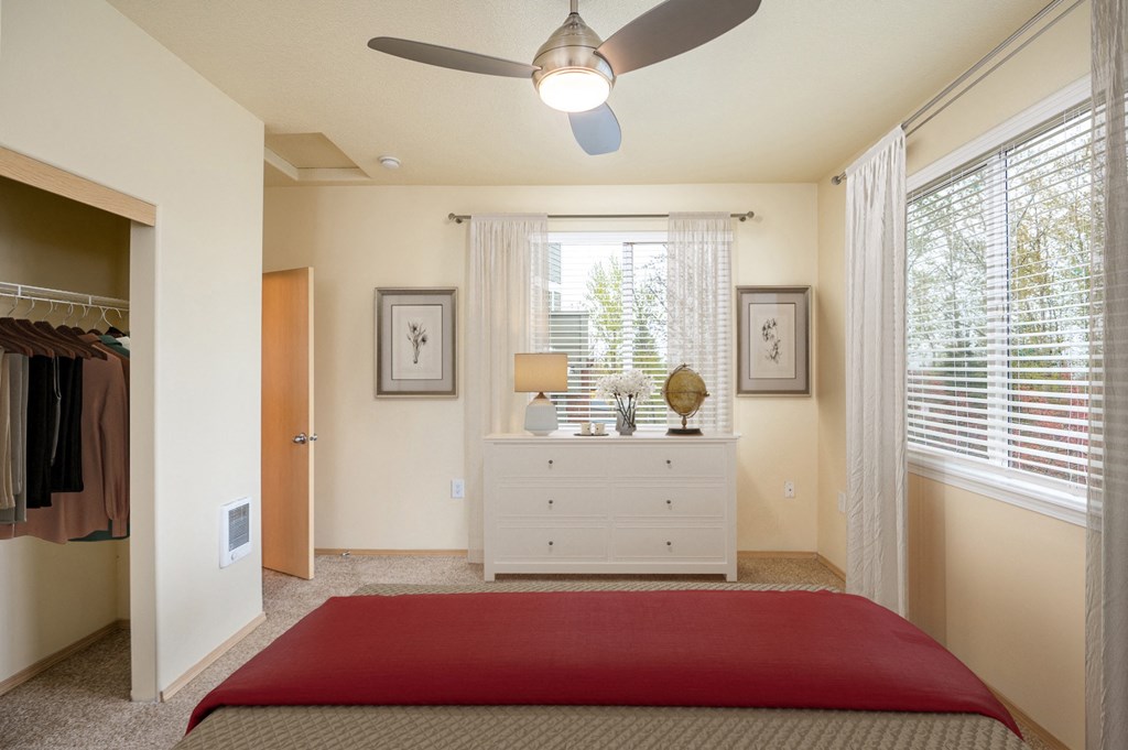 a bedroom with a bed and a dresser and a ceiling fan
