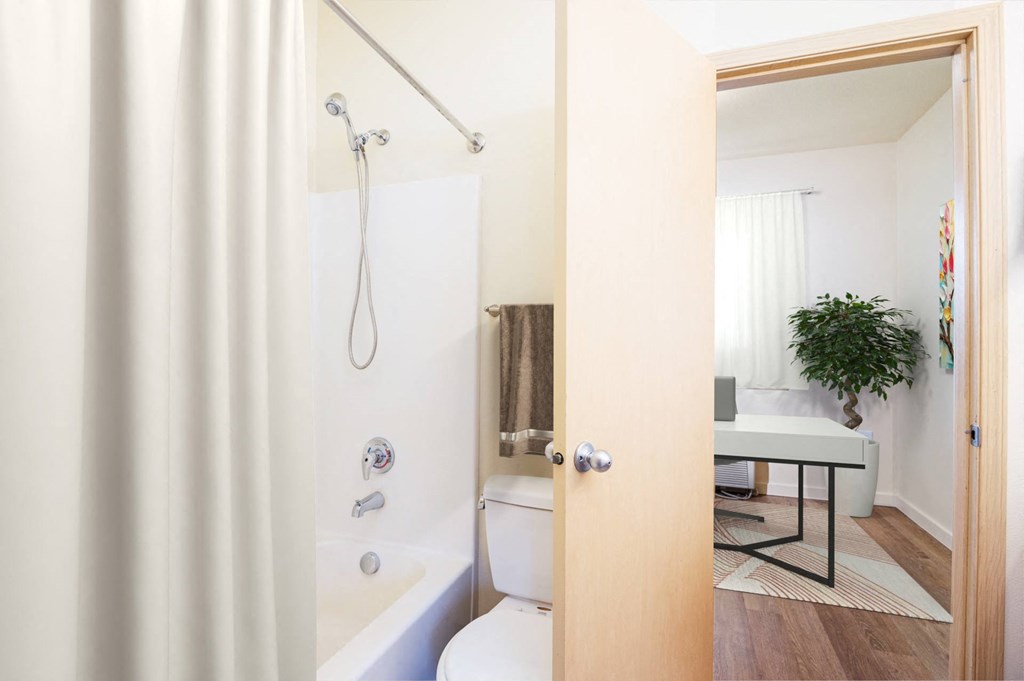 a white bathroom with a shower and a toilet