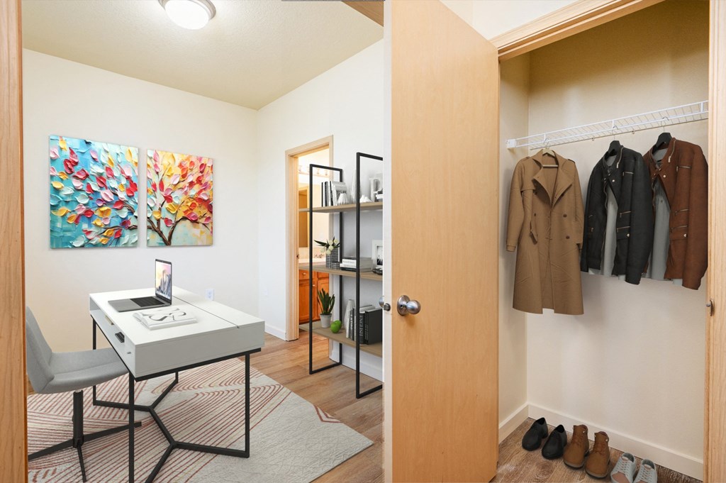 a closet with a white desk and a door to a closet