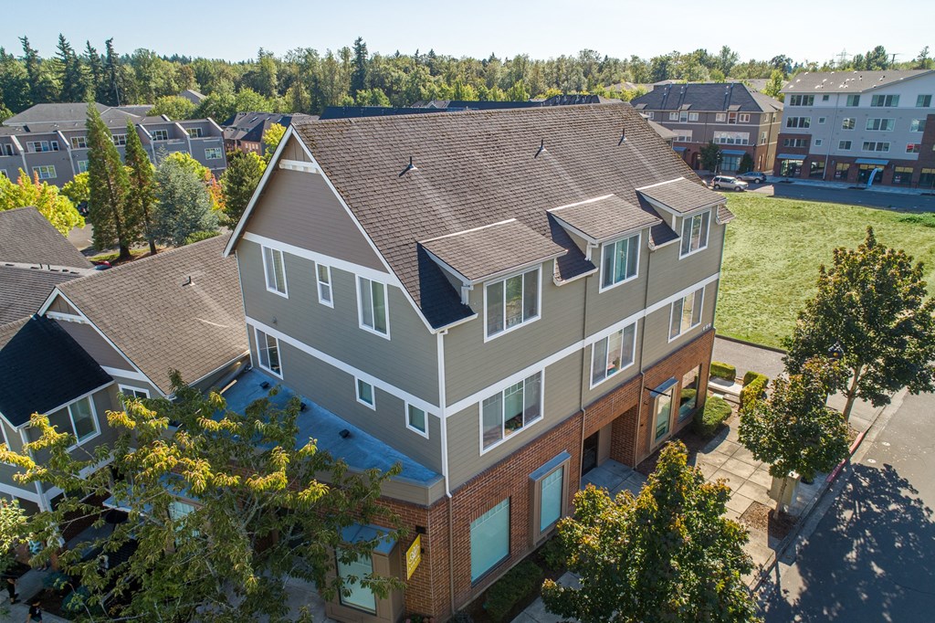 an aerial view of a house with a green lawn and trees