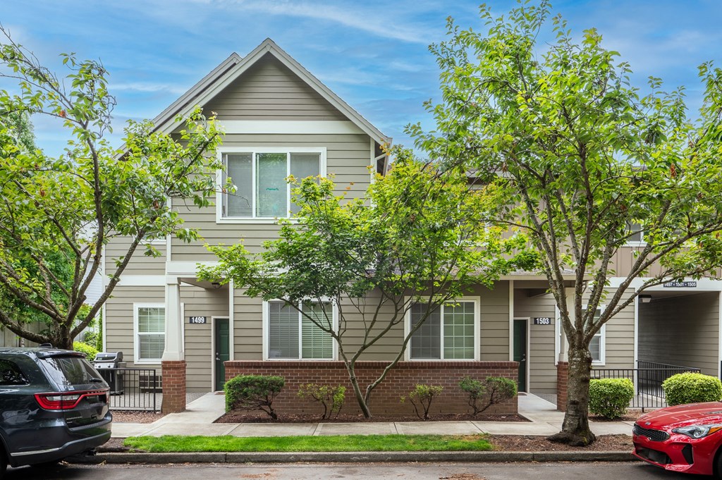 an apartment building with two cars parked in front of it