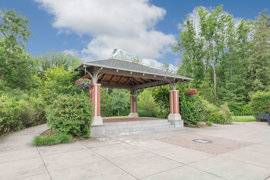a gazebo with a stone wall and brick pillars