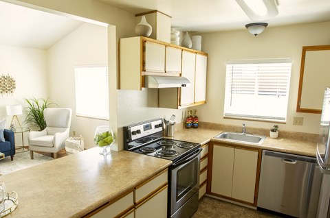 A kitchen with a stove top oven, microwave, and sink.
