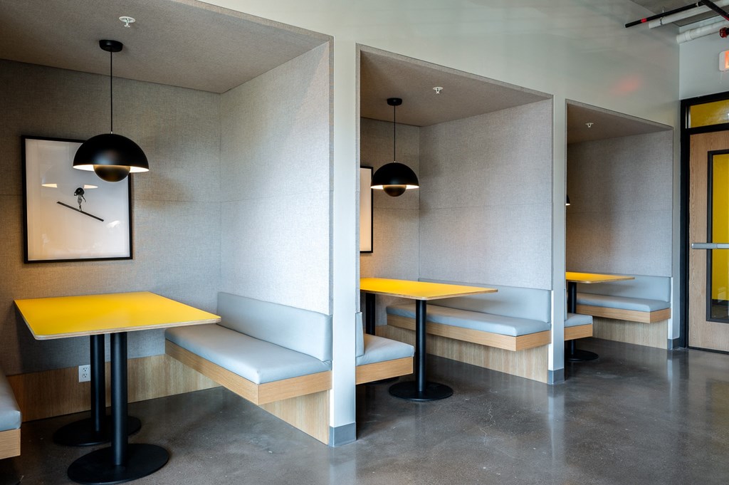 two tables with yellow tops in a room with benches