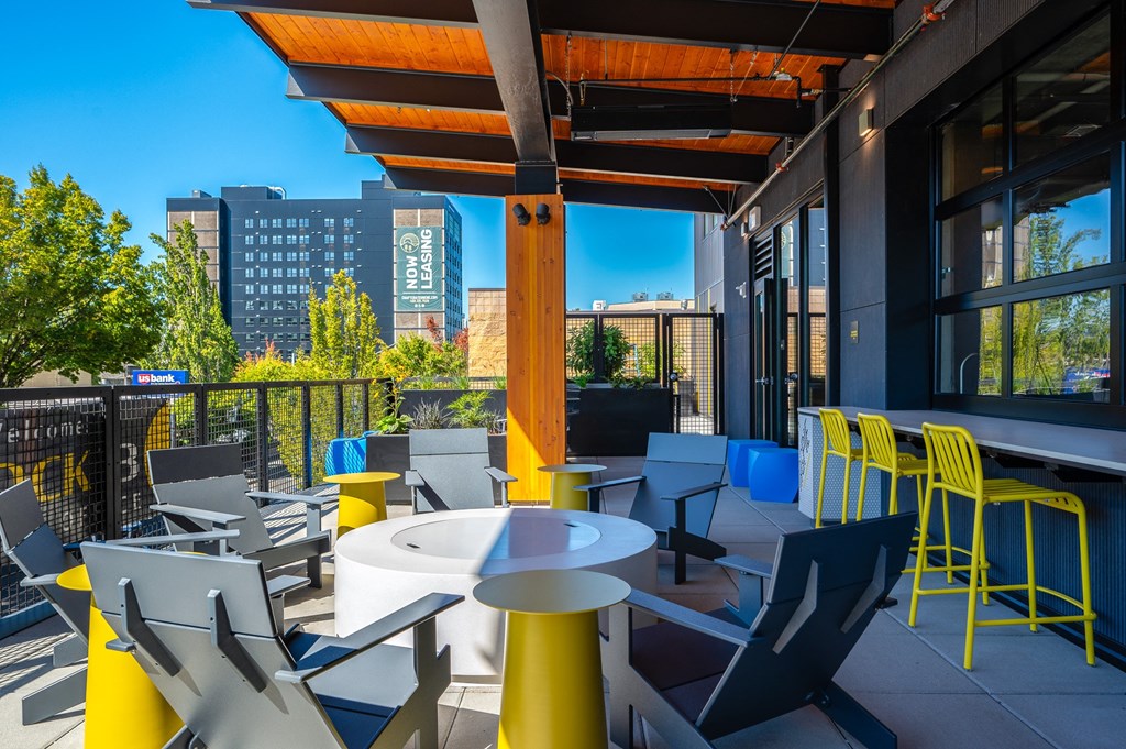 a rooftop patio with tables and chairs and a view of the city
