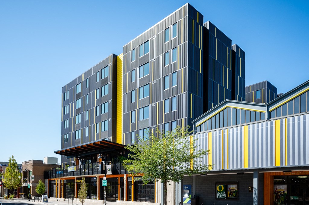 a modern apartment building with a yellow and gray facade in Eugene, Oregon