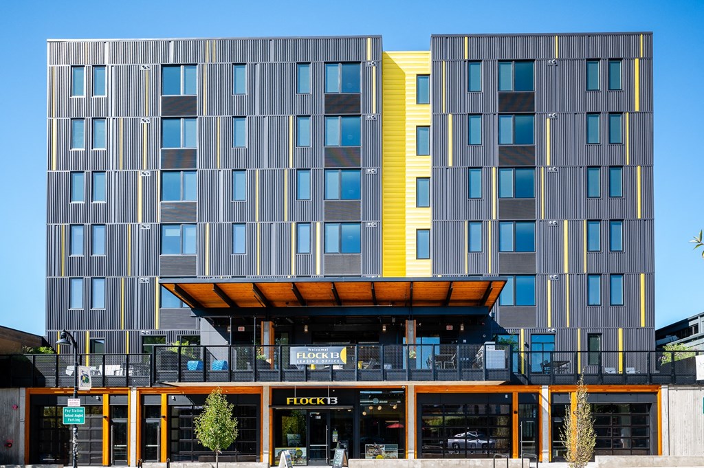 a modern apartment building with a yellow and grey facade