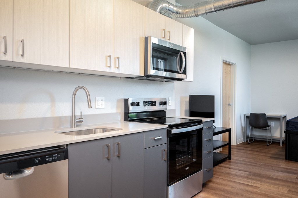 a kitchen with white cabinets and a sink and a microwave