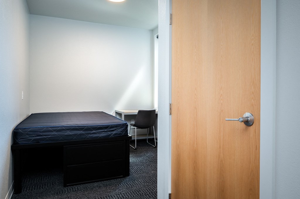 an empty room with a bed and a door