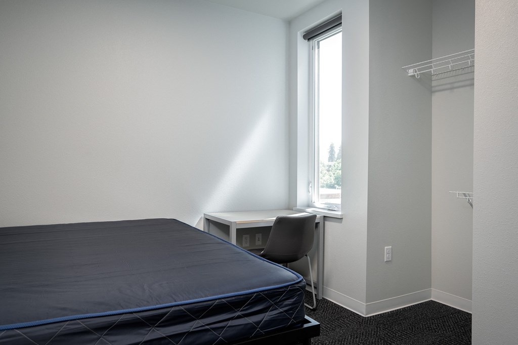 a small bedroom with a bed and a window