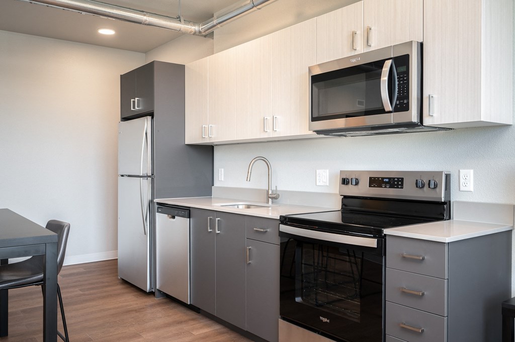 a kitchen with white cabinets and a black counter top