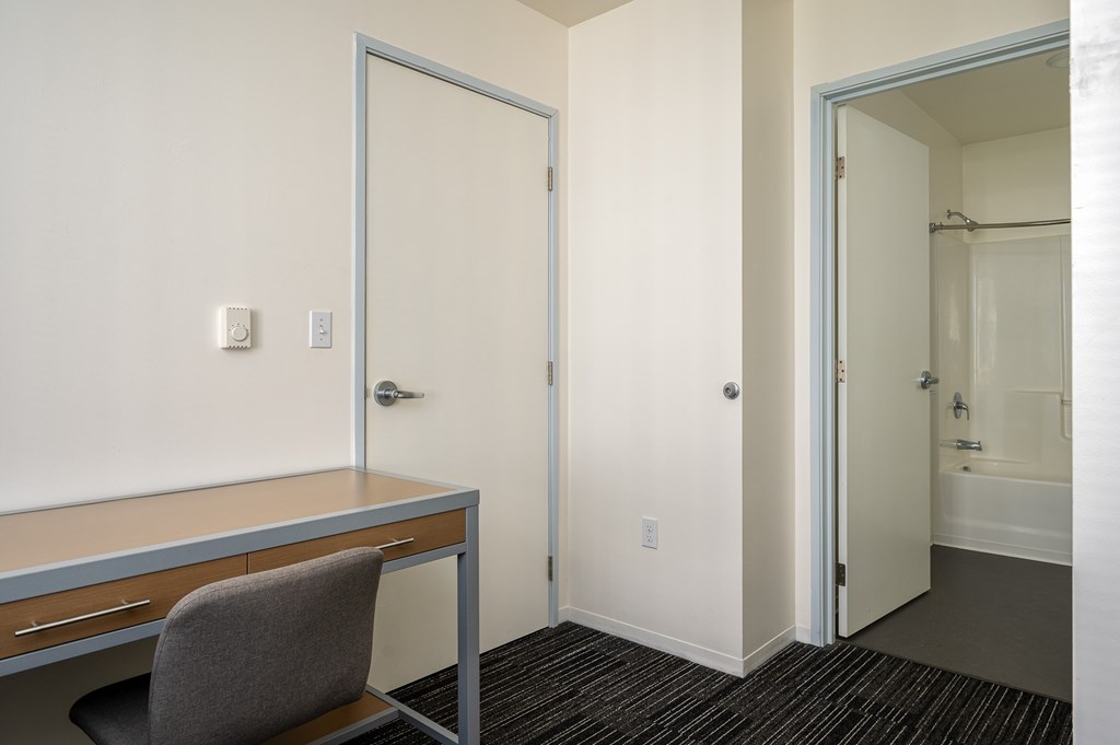 A room with a desk and chair in it.