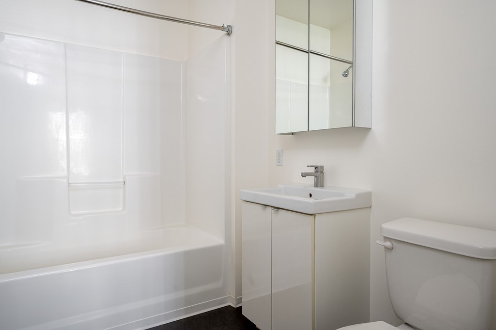 A white bathroom with a sink, toilet, and bathtub.
