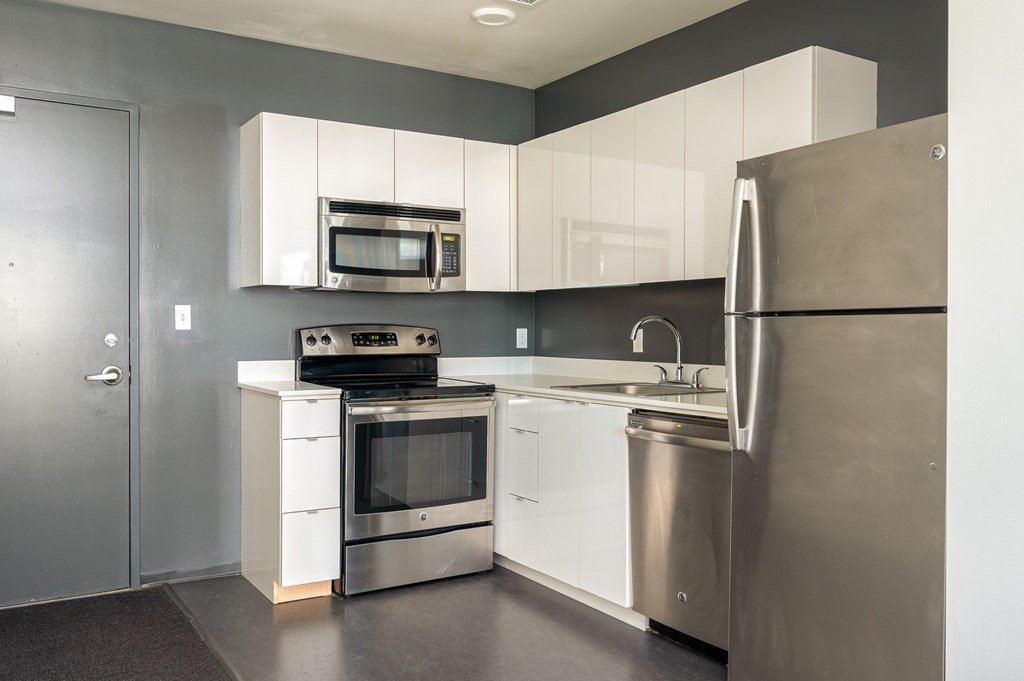 A modern kitchen with stainless steel appliances and white cabinets.