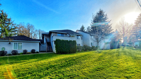 A house with a green lawn in front of it.