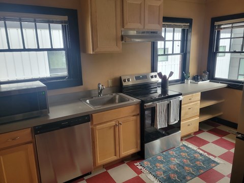 A kitchen with a checkered floor and wooden cabinets.