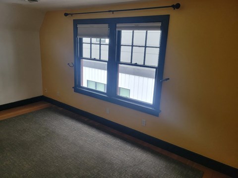 A room with a window and a carpet.