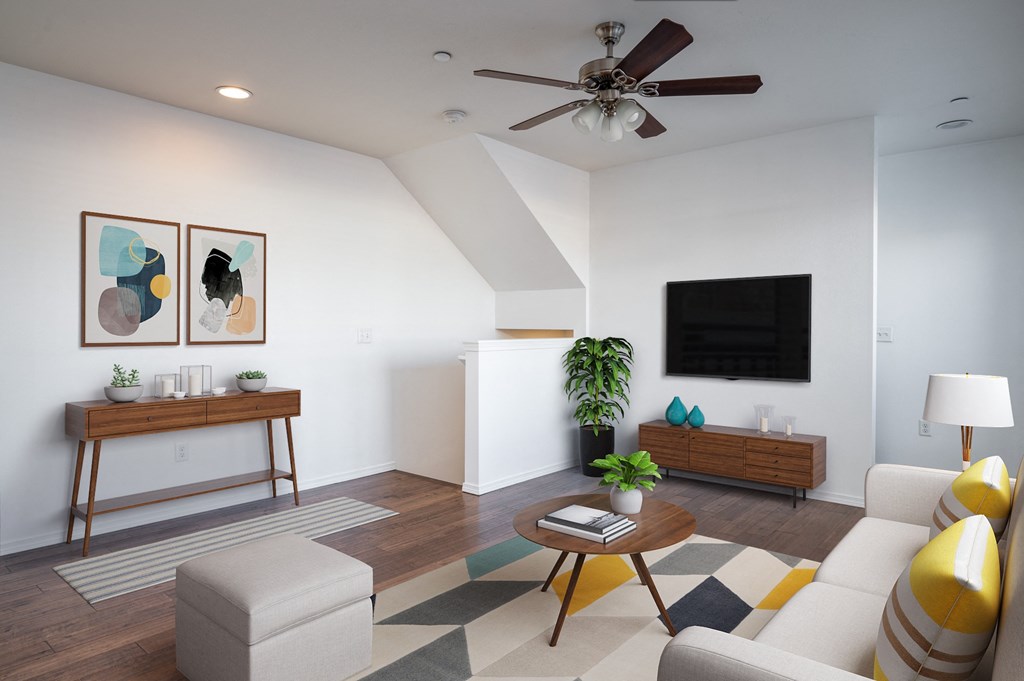 a living room with white walls and a ceiling fan