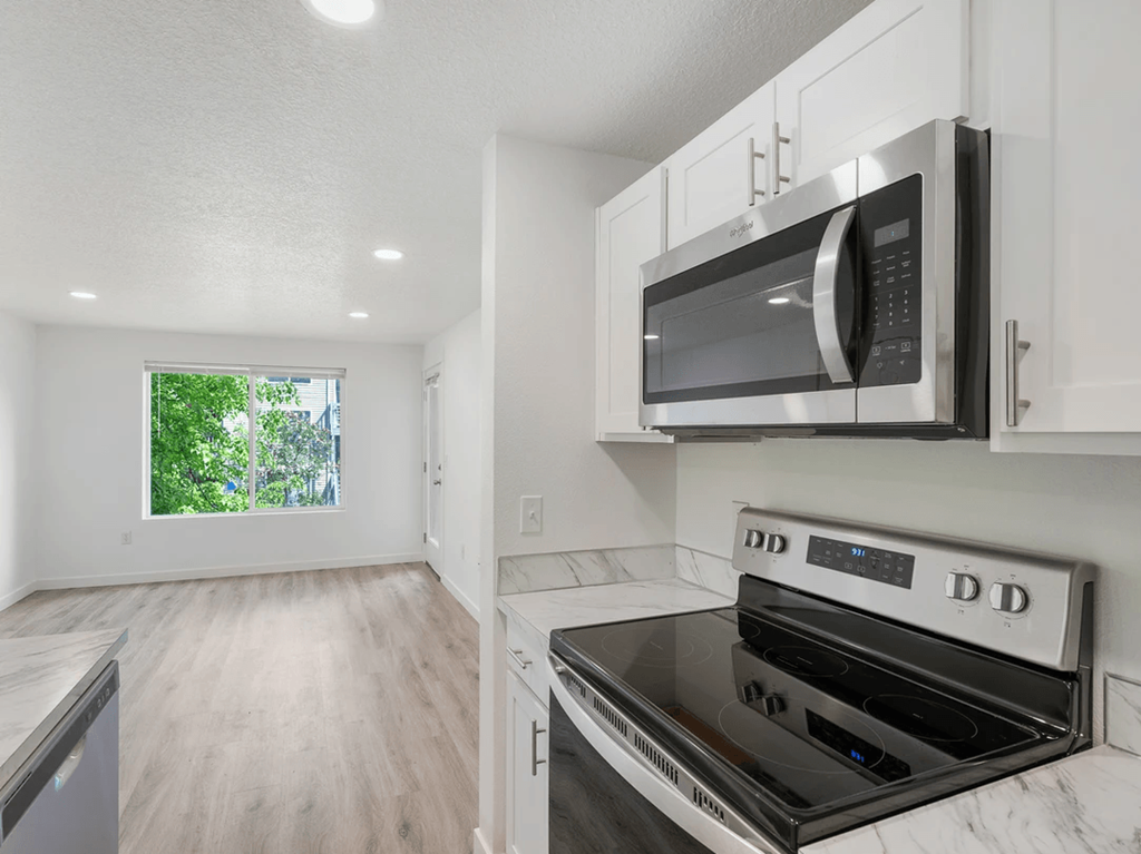 a kitchen with white cabinets and a black stove top oven