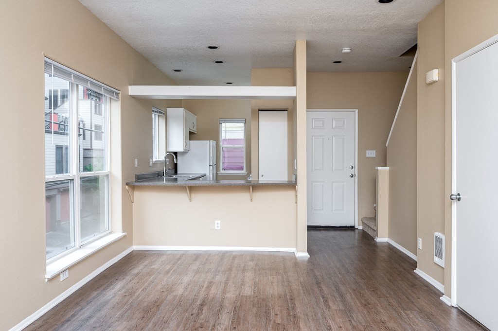 the living room and kitchen of an empty house with a large window