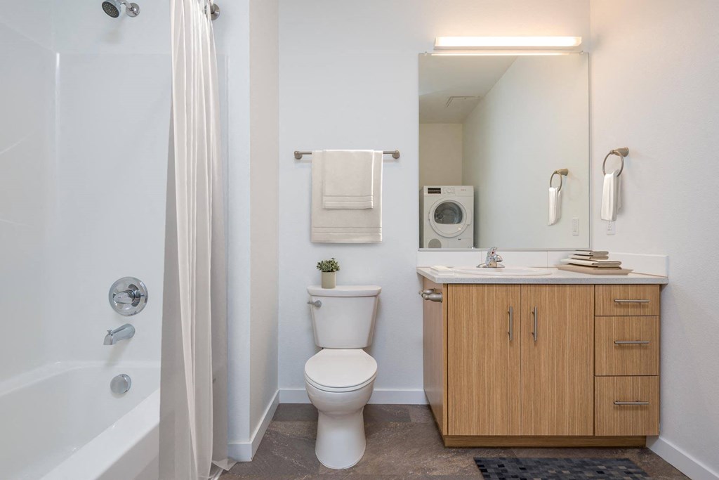 a bathroom with a toilet sink and shower and a mirror