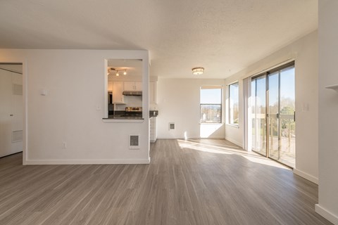 a bedroom with hardwood floors and a sliding glass door leading to a balcony