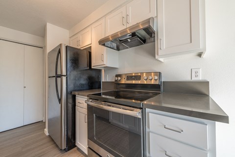 A modern kitchen with a stainless steel refrigerator and oven.