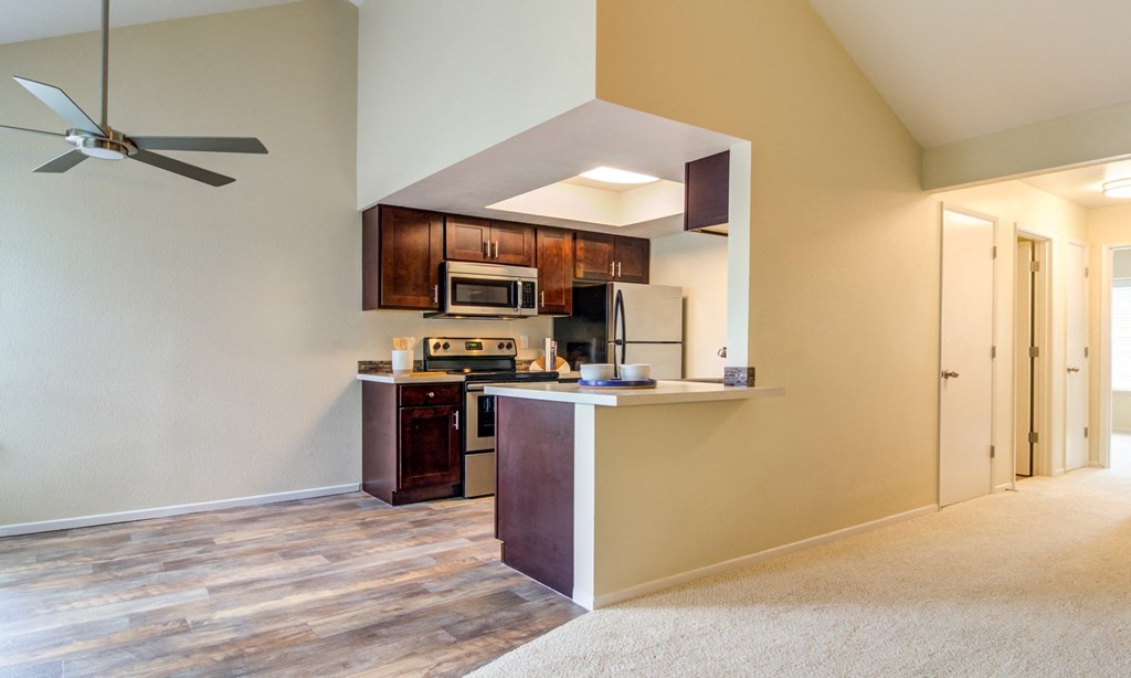 an open kitchen and living room with a ceiling fan