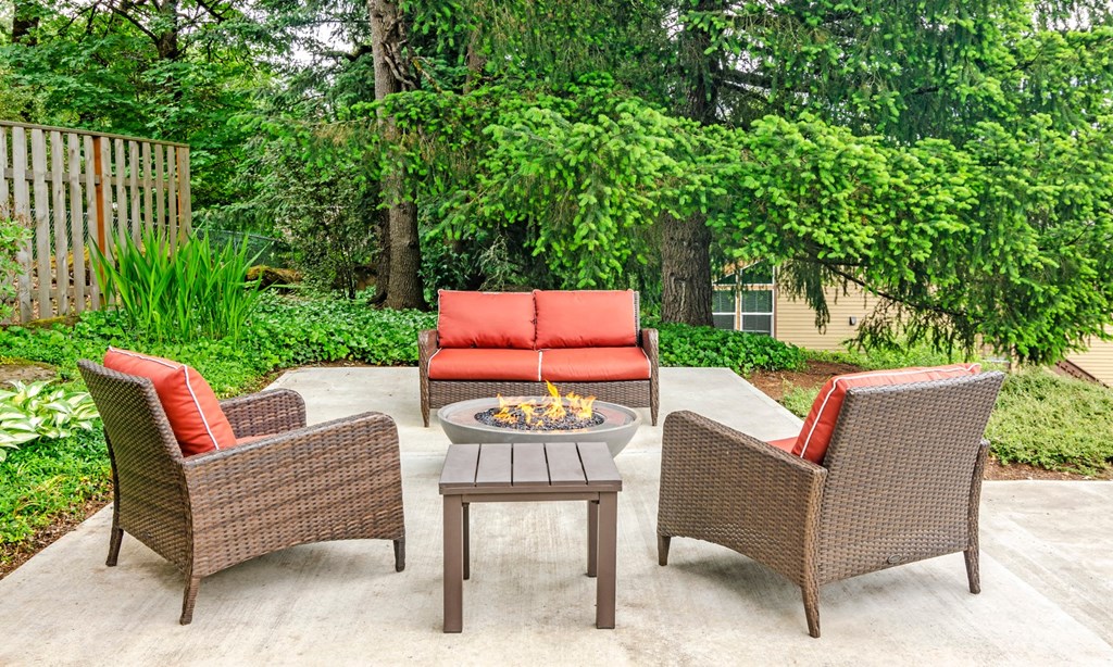 a patio with chairs and a fire pit