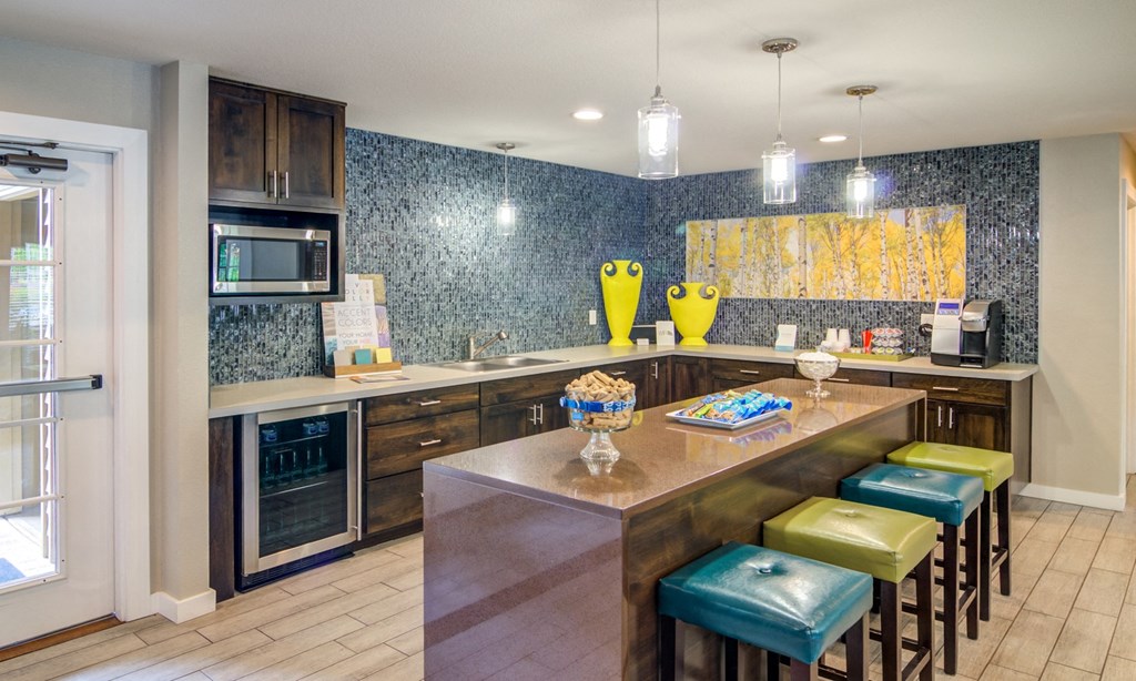 a kitchen with a large island with stools and a sink