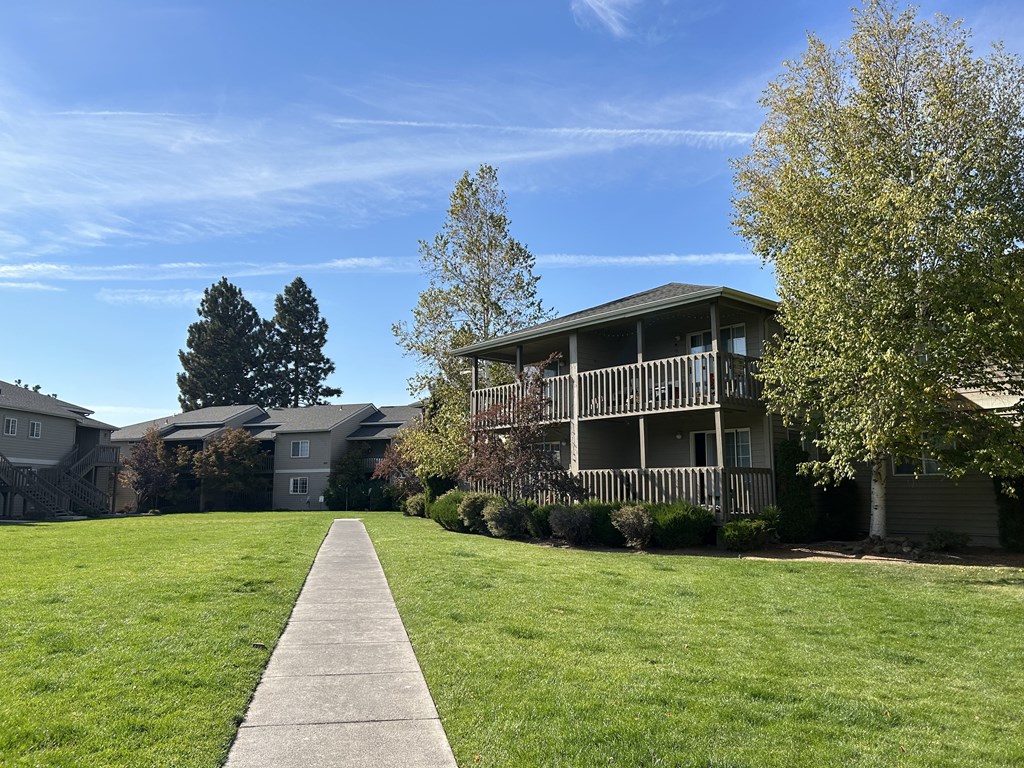 a grassy area with an apartment complex in the background