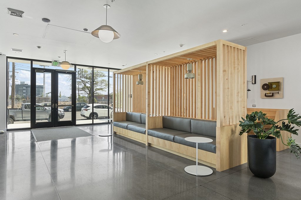 a seating area with a couch and a potted plant in front of a glass door