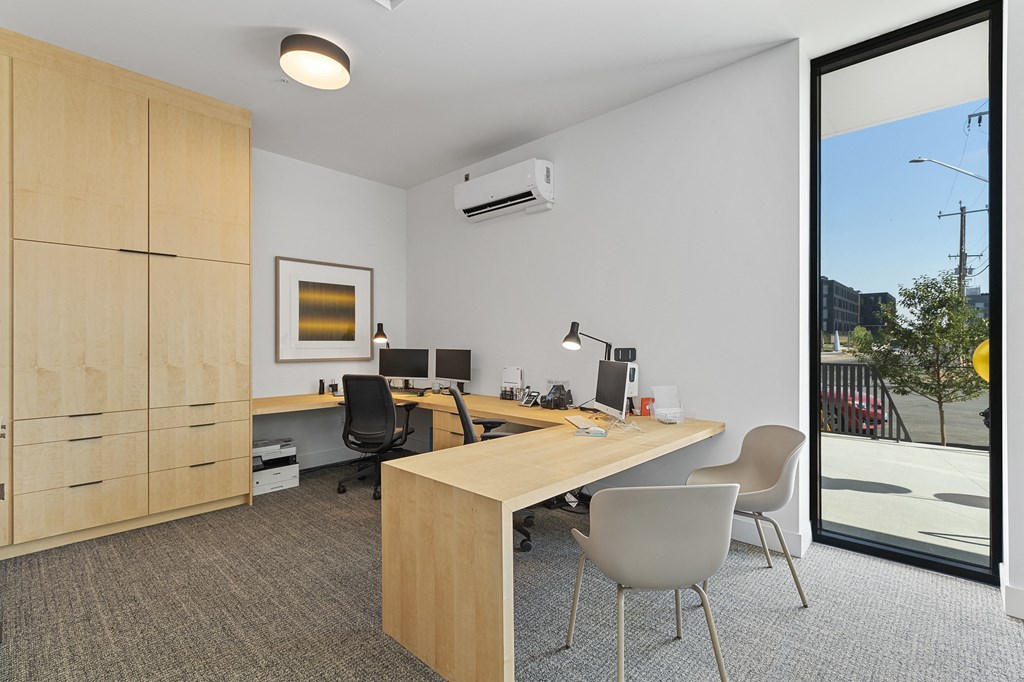 a room with a desk and chairs