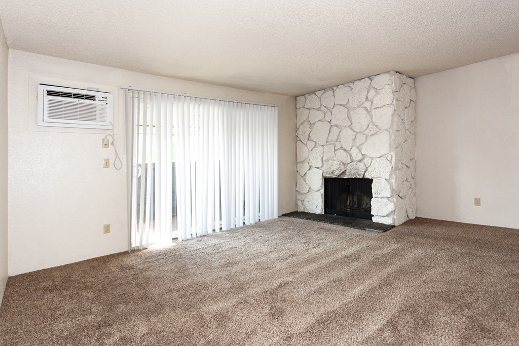 an empty living room with a fireplace and a window