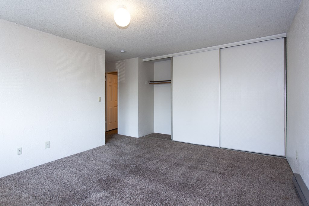 an empty living room with white walls and carpet