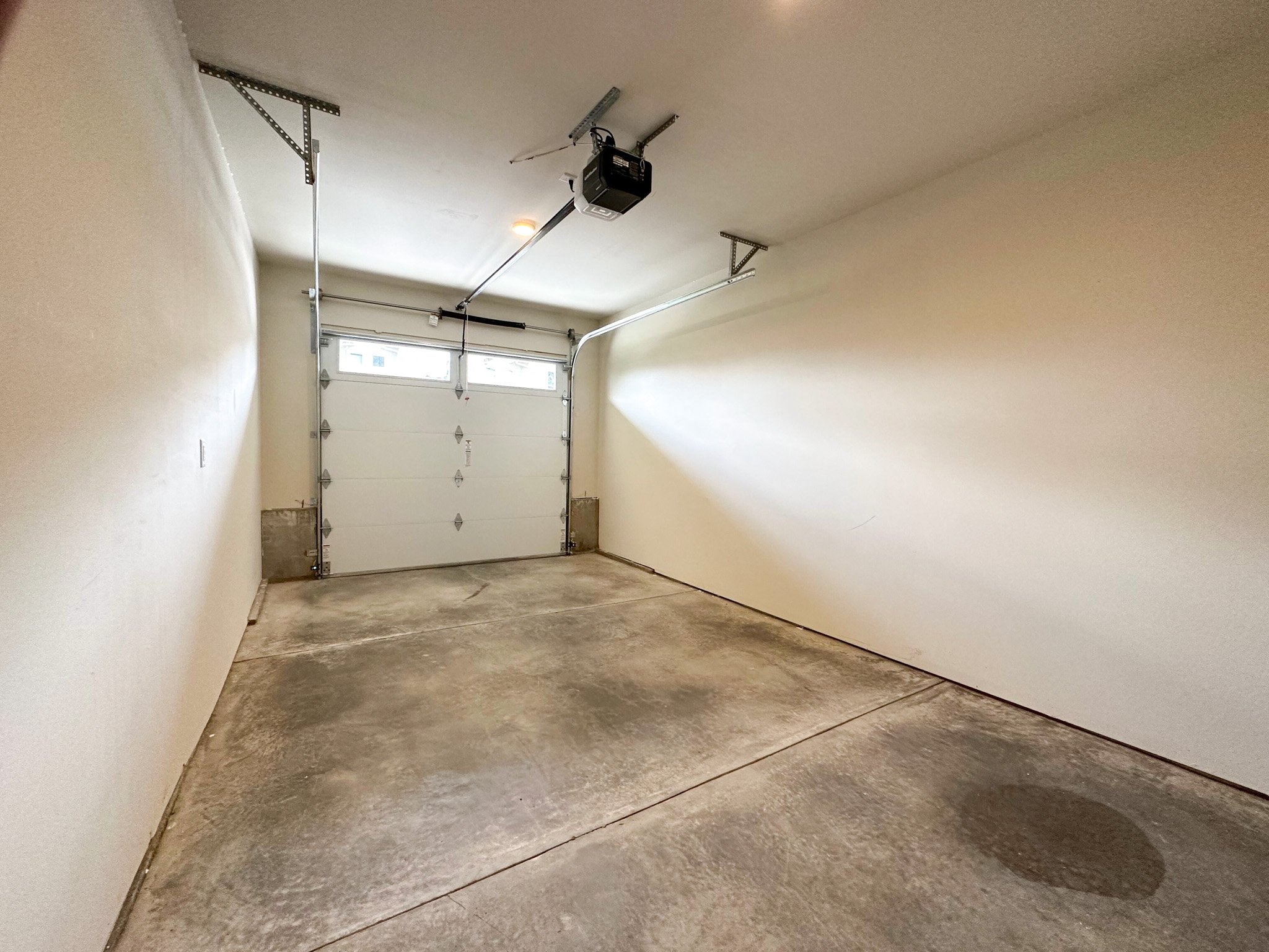 a garage with a white door and a ceiling fan