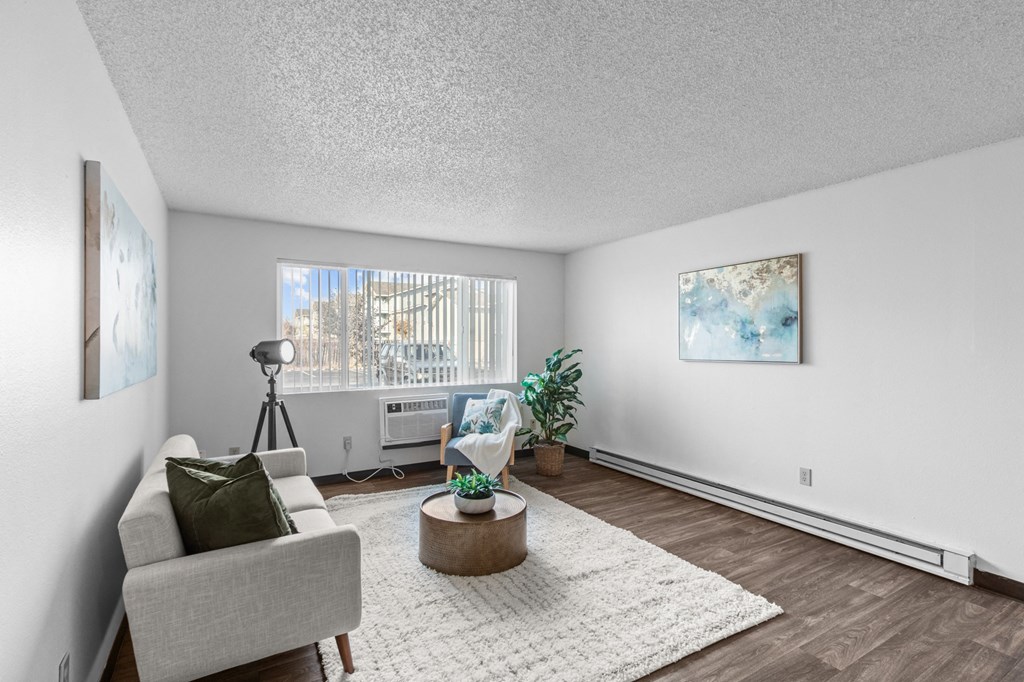 the living room of an apartment with a couch and a chair