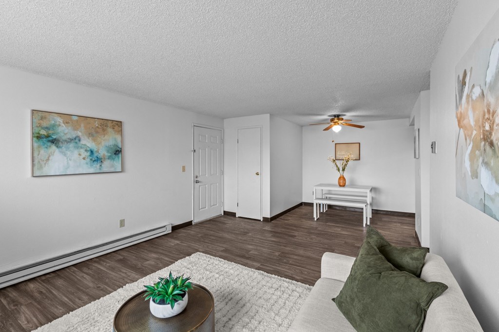 a living room with white walls and a ceiling fan