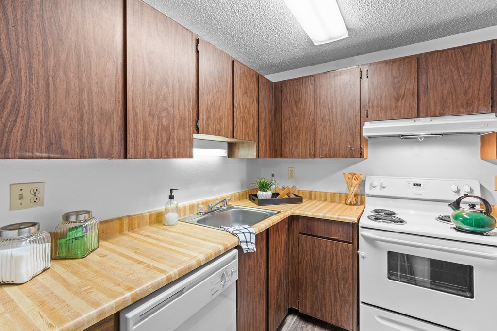 a kitchen with white appliances and wooden counter tops