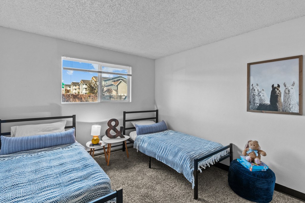 a bedroom with two twin beds and two paintings on the wall