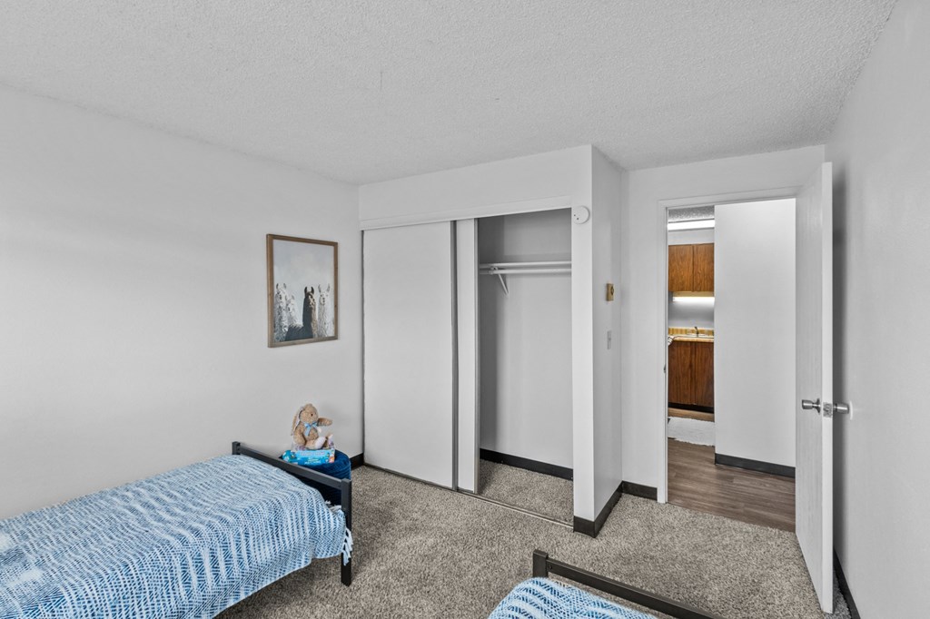 a bedroom with a bed and a closet and a bathroom