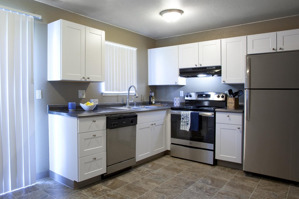 a kitchen with white cabinets and stainless steel appliances