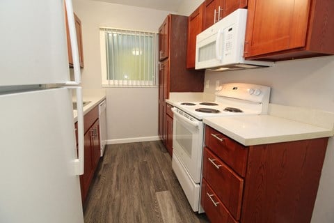 a kitchen with white appliances and wooden cabinets and a white stove