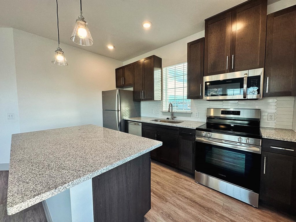 a kitchen with a granite counter top and stainless steel appliances