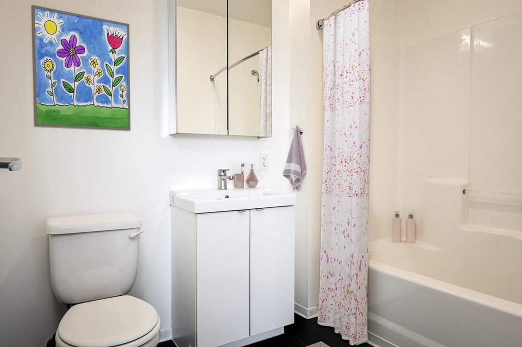 A white toilet sits next to a white sink in a bathroom.