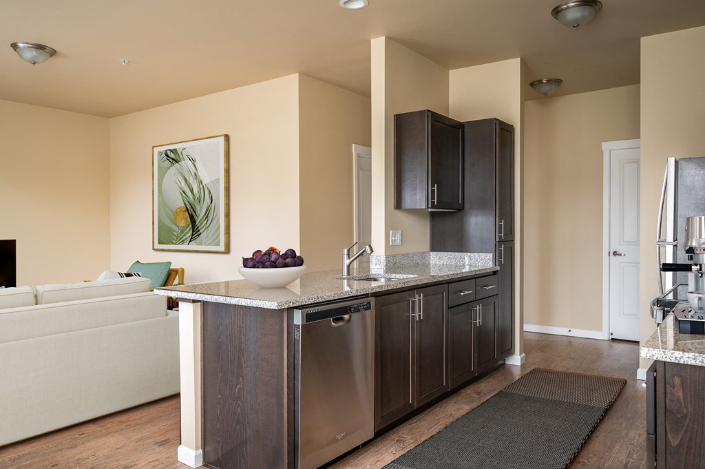 A kitchen with a white sofa and a painting of a flower on the wall.